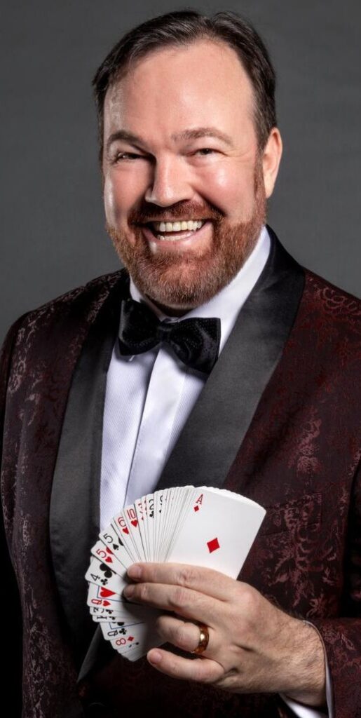 Matt Donnelly Mind Noodler smiling in tux fanning out cards